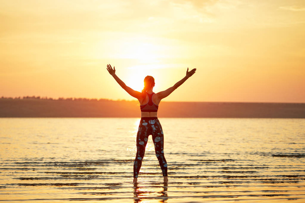Yoga en fitness. Jonge vrouw beoefenen ochtend meditatie in de natuur op het strand - Foto, afbeelding