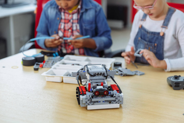 Mixed Racial group of School kids sitting at class with diy robot, stem education concept. - Фото, изображение