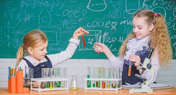 School laboratory partners. Kids busy with experiment. Chemical analysis and observing reaction. Test tubes with colorful substances. School equipment for laboratory. Girls on school chemistry lesson - Foto, immagini