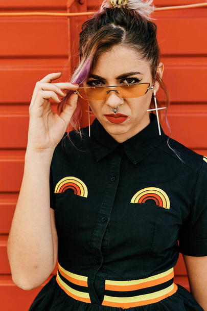 ein Mädchen mit Ekelgesicht mit alternativem Look und Brille - Lifestylekonzept - Foto, Bild