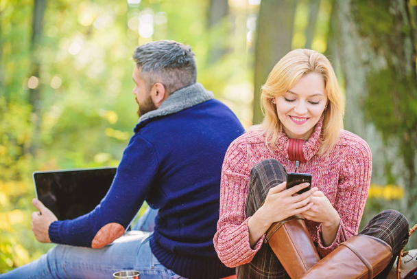 Modern life. Happy loving couple relaxing in park with mobile gadgets. Modern people always involved online communication. Internet addiction. Online life modern technology. Logout of all accounts - Photo, image
