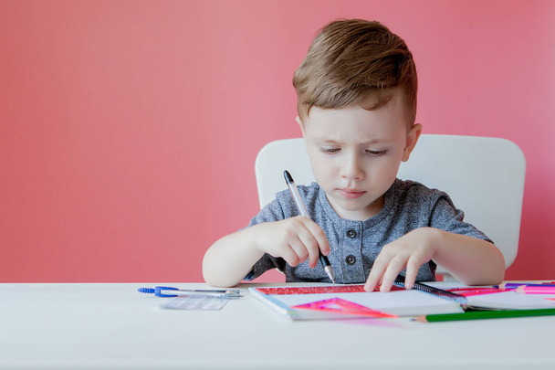 Portrait of cute kid boy at home making homework. Little concent - Foto, Bild