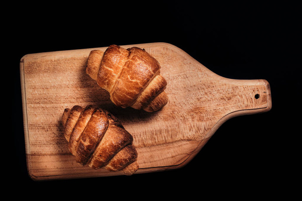 two tasty crispy French croissant.dark background.top view. - Foto, afbeelding