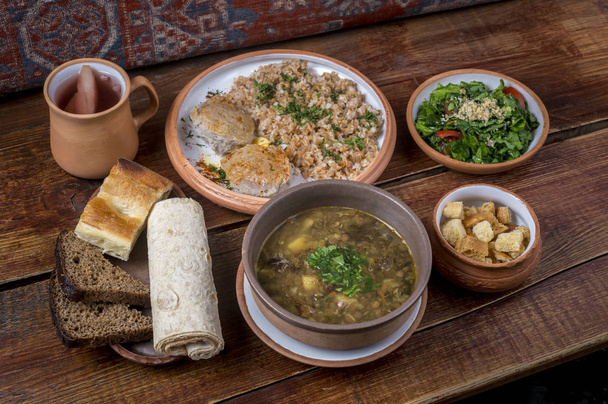 Блюда ближневосточной кухни в керамических тарелках на деревянном столе
 - Фото, изображение
