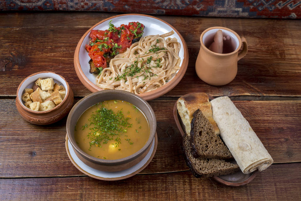 Блюда ближневосточной кухни в керамических тарелках на деревянном столе
 - Фото, изображение