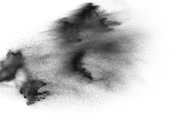 Explosion von schwarzem Sand vor weißem Hintergrund. Sandpartikel auf weißem Hintergrund. - Foto, Bild