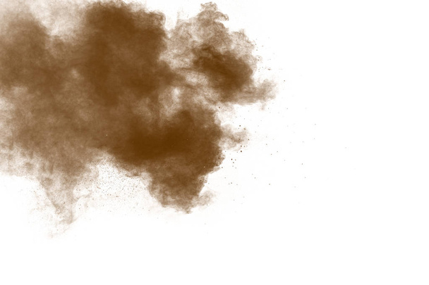 Freeze motion of brown powder exploding. Abstract design of color powder cloud against white background. - Photo, Image