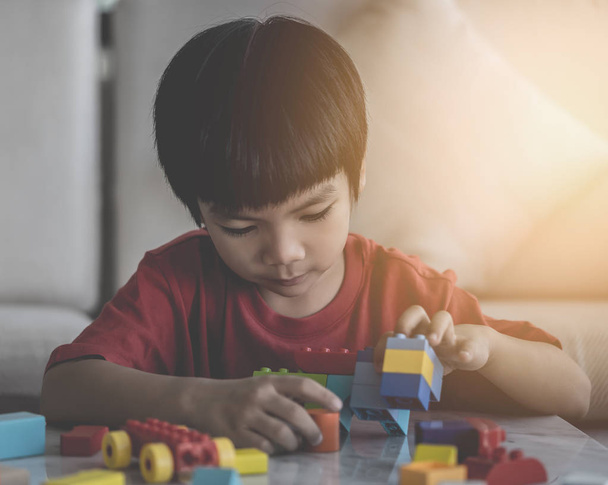 Asian boy stacking Toy blocks on a living room table - Foto, Imagem