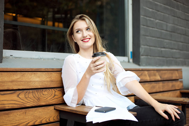 Portrait of young businesswoman use mobile phone while sitting in comfortable coffee shop during work break, charming happy female reading fashion news on cell telephone during breakfast in restaurant - Fotó, kép