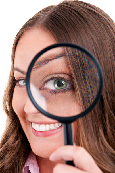 Beautiful woman looking through a magnifying glass - Фото, зображення