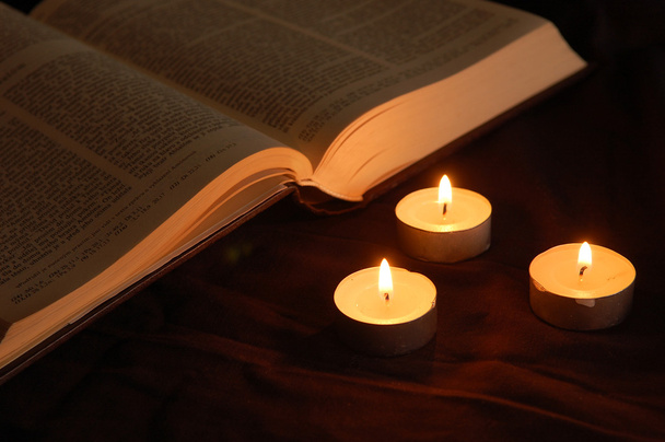 Lit candles and opened Bible - Фото, изображение