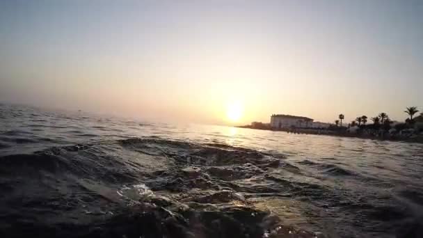 Чоловічі ноги плавають у спокійному пляжі на заході сонця влітку - вид з першої особи
 - Кадри, відео