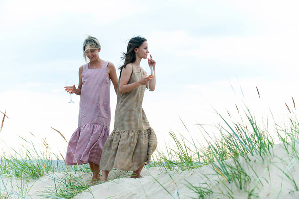 Kaksi nuorta viehättävää naista lepää ja juo valkoista kesää voittaa
 - Valokuva, kuva