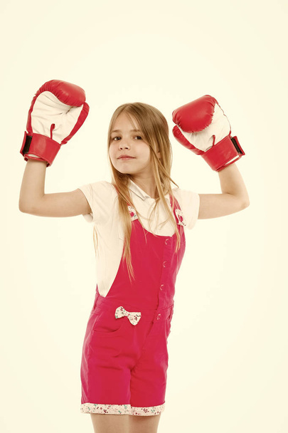 Little girl smile after boxing training isolated on white. Happy child raised hands in boxing gloves. Punching. Childhood development and health. Kid boxer show power. I am the best. Sport and energy - 写真・画像