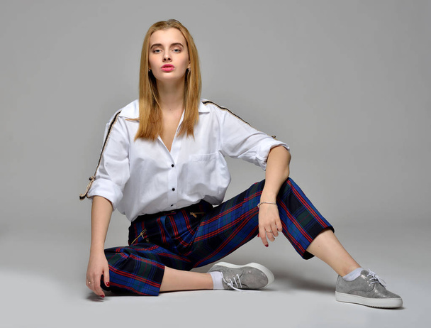 beautiful blonde woman in white shirt and checked trousers - Фото, зображення