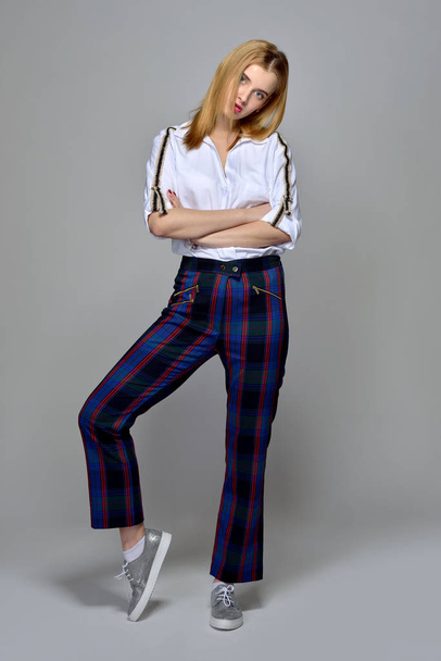 beautiful blonde woman in white shirt and checked trousers - Photo, image