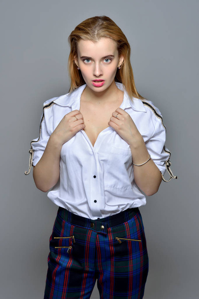 beautiful blonde woman in white shirt and checked trousers - Valokuva, kuva