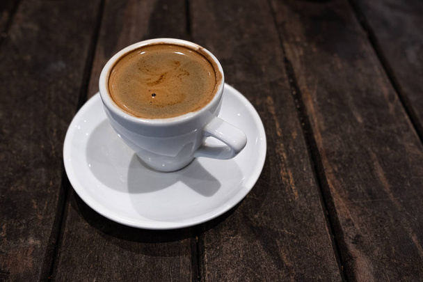 dvojité espresson v bílém poháru proti tmavému pozadí - Fotografie, Obrázek
