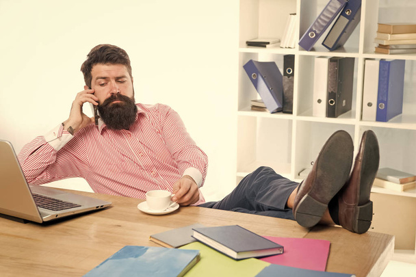 Office job benefits.Modern occupation. Guy bearded man brutal web developer call colleague while drinking coffee. Man with laptop works as smm expert web developer or programmer. IT developer - Foto, Imagem