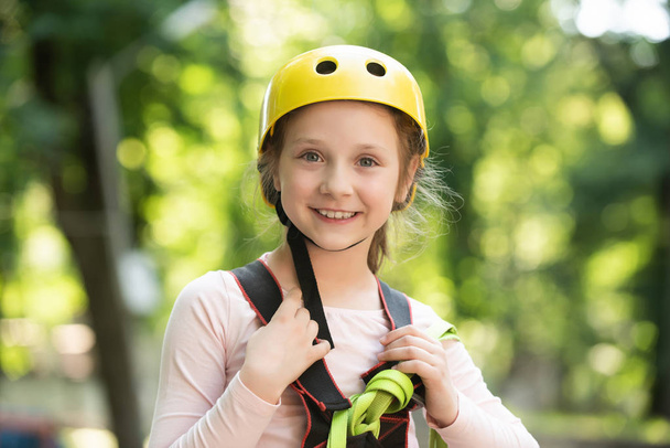 Go Ape Adventure. Happy Little girl climbing on a rope playground outdoor. Little girl concept. High ropes walk. Early childhood development. Children fun. - Photo, image
