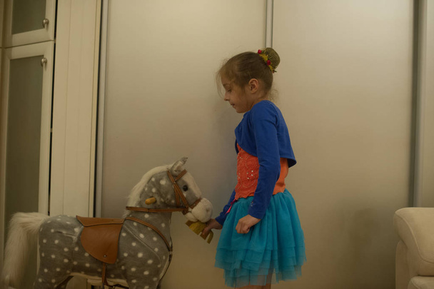 Menina brinca com uma maca de cavalo
 - Foto, Imagem