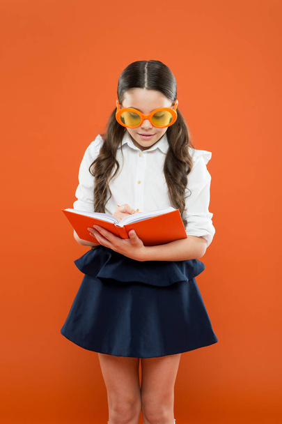 make some notes. writing in workbook. children literature. get information from book. happy school girl in uniform and party glasses. small child with notebook. literature lesson education - Foto, immagini