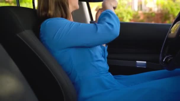Woman fastening car safety seat belt while sitting inside of vehicle before driving - Filmagem, Vídeo