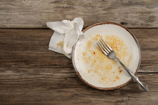 un plato sucio vacío en la mesa de madera después de la cena
 - Foto, Imagen