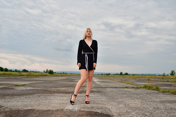 Seksowna blondynka w mini spódnicy na pasie startowym - Zdjęcie, obraz