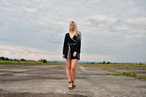sexy blonde in een mini rok op runway - Foto, afbeelding