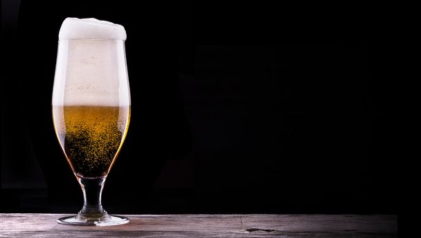 Холодный стакан светлого пива на черном фоне
 - Фото, изображение