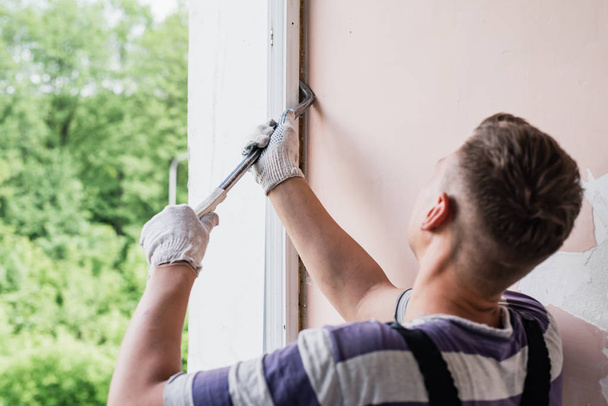 Processo trabalhador masculino reparar janela em uma casa, close-up
 - Foto, Imagem