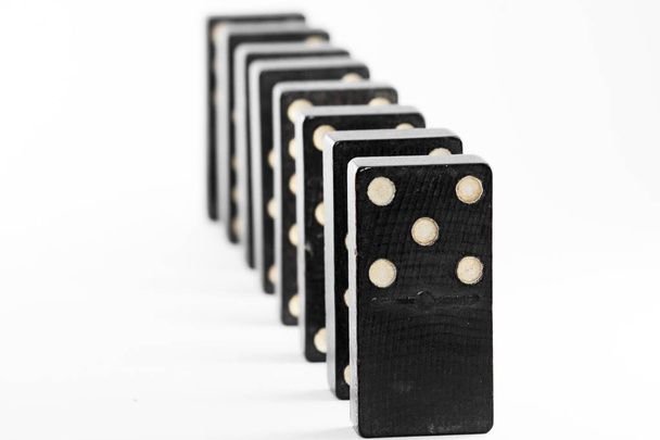 Domino muotoili asennon eri tavoin, mustana, valkoisella pohjalla. Peli domino
. - Valokuva, kuva