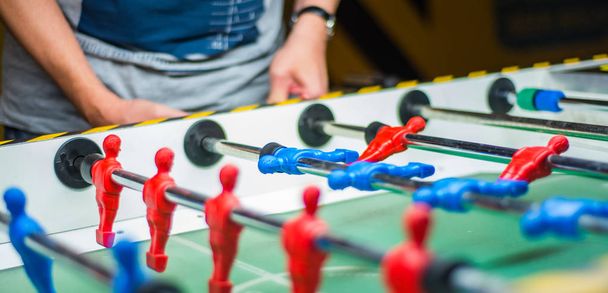 A man plays table football. Detail of man's hands playing the kicker - Photo, Image