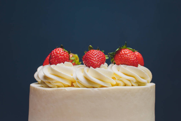 Cake decorated with isomalt shape and strawberries on blue background. - Photo, image