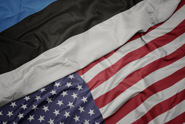 falujące kolorowe flagi Stanów Zjednoczonych Ameryki i flagi narodowej Estonii. - Zdjęcie, obraz