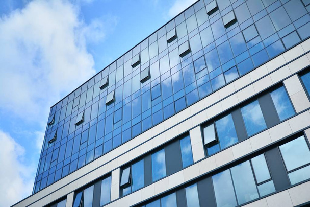 ビジネスセンターに新しいオフィスビル。青空のスチールとガラスで作られた壁。近代的な企業アーキテクチャ - ビジネスと成功の概念. - 写真・画像