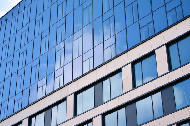 Nuevo edificio de oficinas en el centro de negocios. Pared de acero y vidrio con cielo azul. Arquitectura corporativa moderna - concepto de negocio y éxito
. - Foto, Imagen