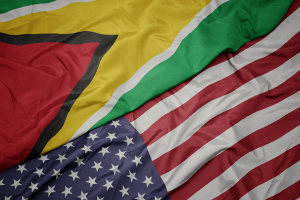 falujące kolorowe flagi Stanów Zjednoczonych Ameryki i flagi narodowej Gujany. - Zdjęcie, obraz
