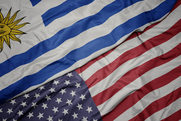 размахивая красочным флагом Соединенных Штатов Америки и национальным флагом Уругвая
. - Фото, изображение