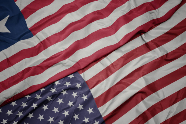 schwenken bunte Flagge der Vereinigten Staaten von Amerika und Nationalflagge Liberias. - Foto, Bild