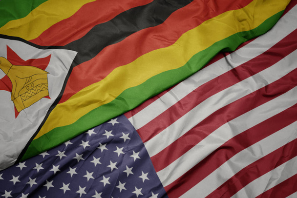 waving colorful flag of united states of america and national flag of zimbabwe. - Photo, Image