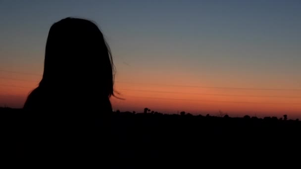 4K. Ultra HD. Silhouette of young woman with dramatic sunset sky background. Always connected, the concept. - Footage, Video