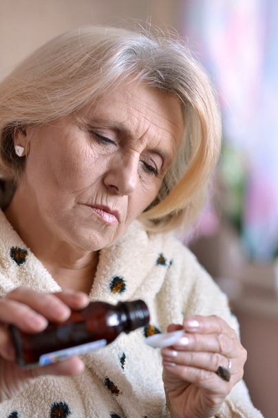 ηλικιωμένη γυναίκα παίρνει ένα φάρμακο - Φωτογραφία, εικόνα