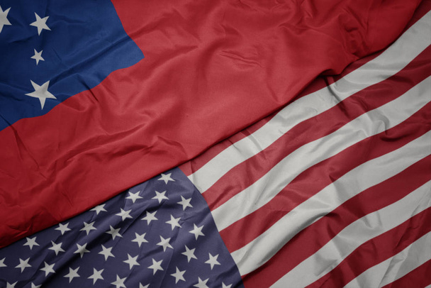 falujące kolorowe flagi Stanów Zjednoczonych Ameryki i flagi narodowej Samoa. - Zdjęcie, obraz