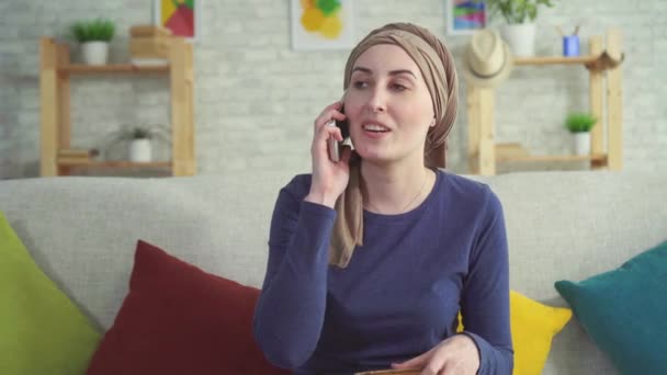 Positive young woman cancer patient after chemotherapy talking on the phone - Felvétel, videó