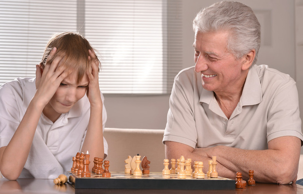 Boy and grandfather playing chess - Valokuva, kuva