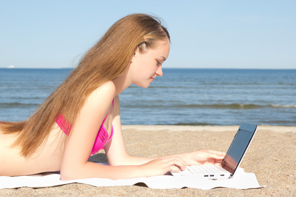 hermosa chica adolescente trabajando en equipo portátil en la playa - Foto, imagen