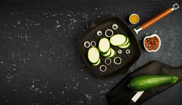 Fresh green zucchini in a pan on a dark table. The view from the top. Copy space. - Фото, зображення