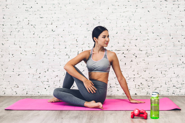 Sportu kobieta siedzi relaks różowy maty i zrobić fitness ćwiczenia wi - Zdjęcie, obraz
